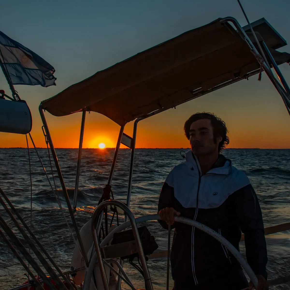 El capitán al timón durante un atardecer en el Río de la Plata
